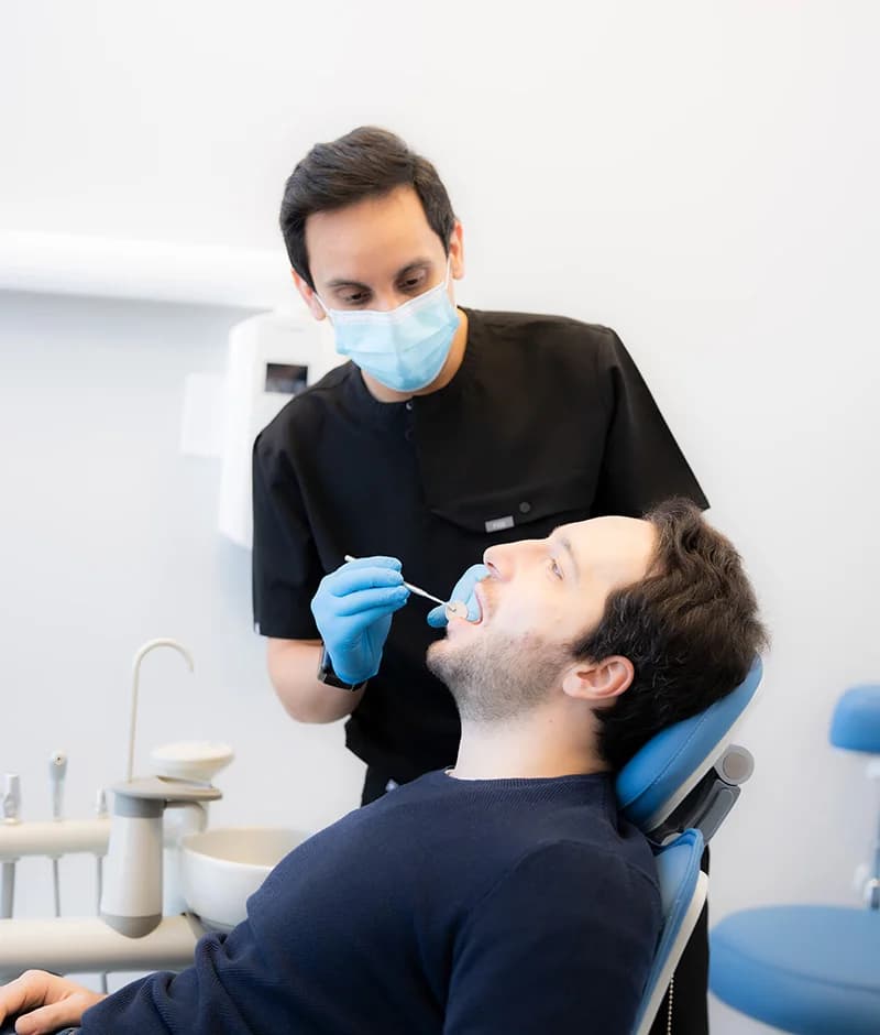 Dr. Rohit Khurana examining a patient chairside at Sauga Smiles Dental
